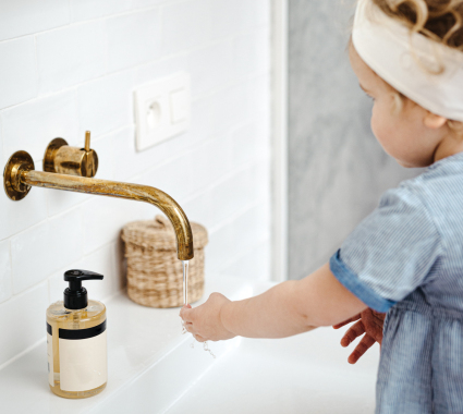 Kind wast handen onder een kraan